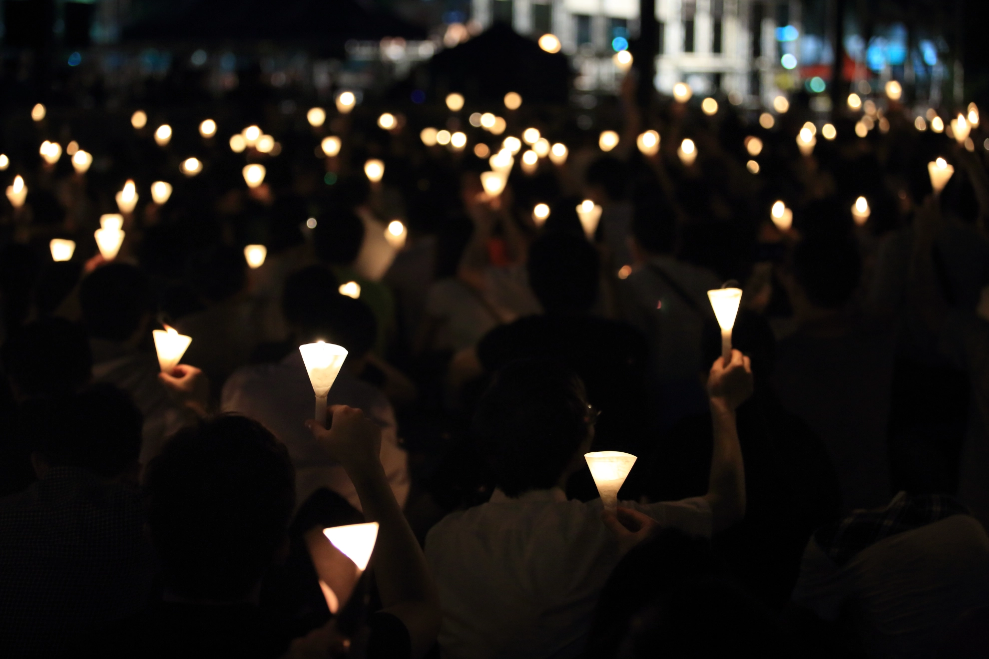 finding the light in dark. a haza candlelight vigil find each other in darkness, blur background in hong kong victoria park